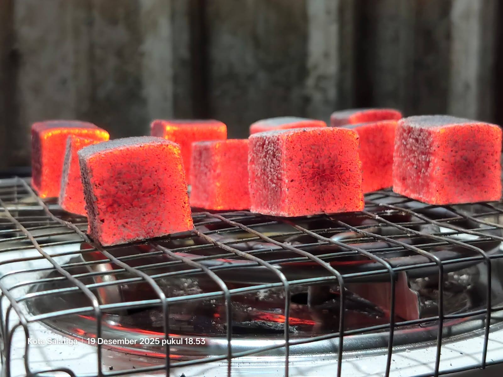 Glowing charcoal briquettes on a grill
